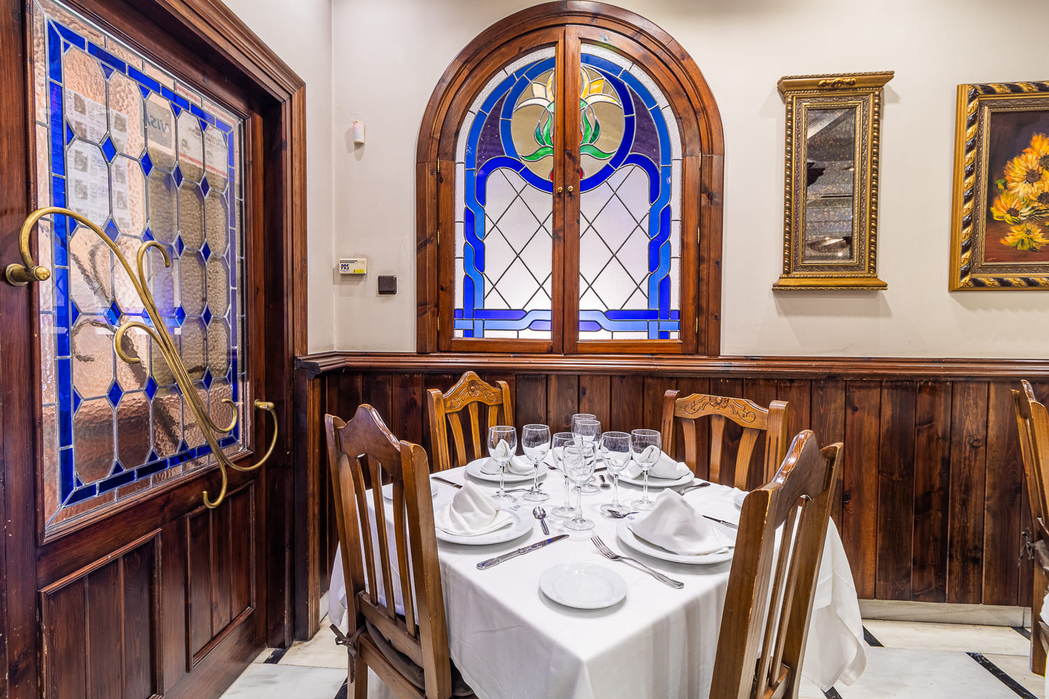 Detalle de la decoración rústica y acogedora del restaurante, con mesas bien dispuestas para eventos especiales.